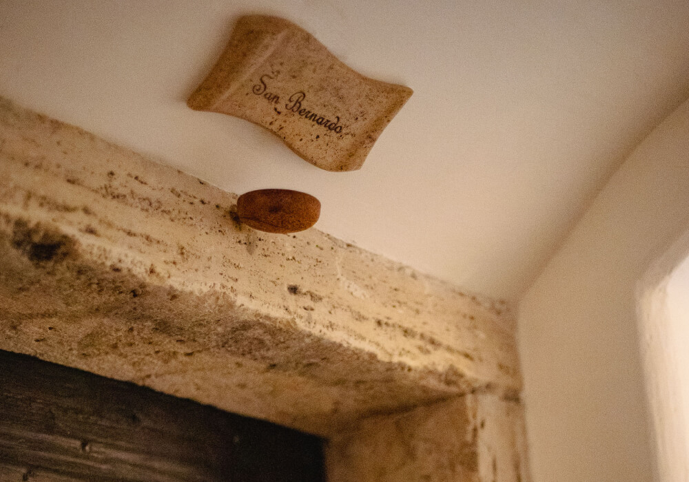 Targa in legno con il nome San Bernardo sulla volta bianca di una celluzza