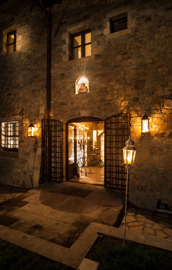 Ingresso di Eremito di notte con porta in legno e lanterne accese