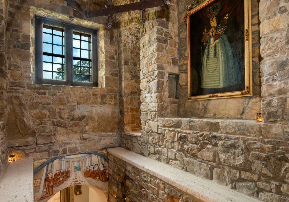 Interno di Eremito con finestra in pietra e dipinto antico alla parete