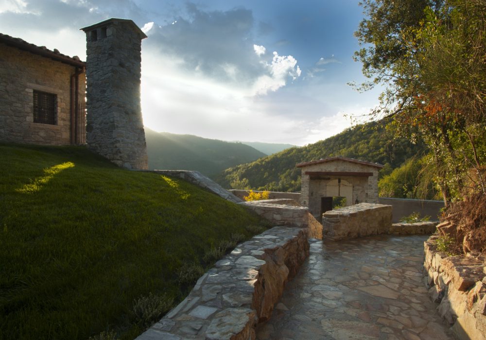 Terrazza in pietra all'alba con la torre di Eremito e le colline umbre