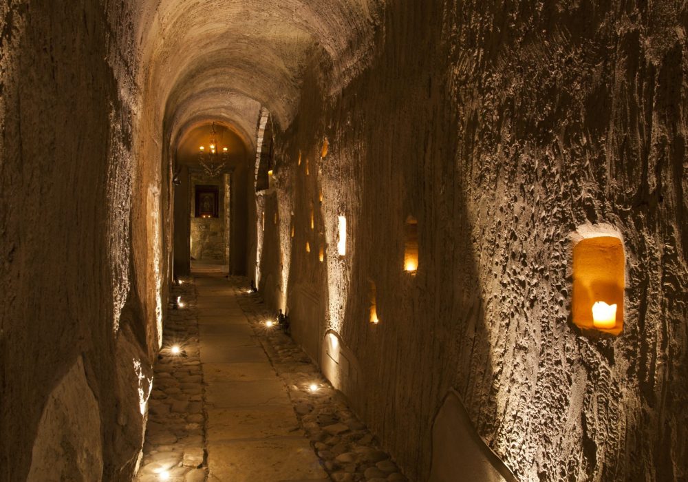 Lungo corridoio illuminato solo da candele e lanterne