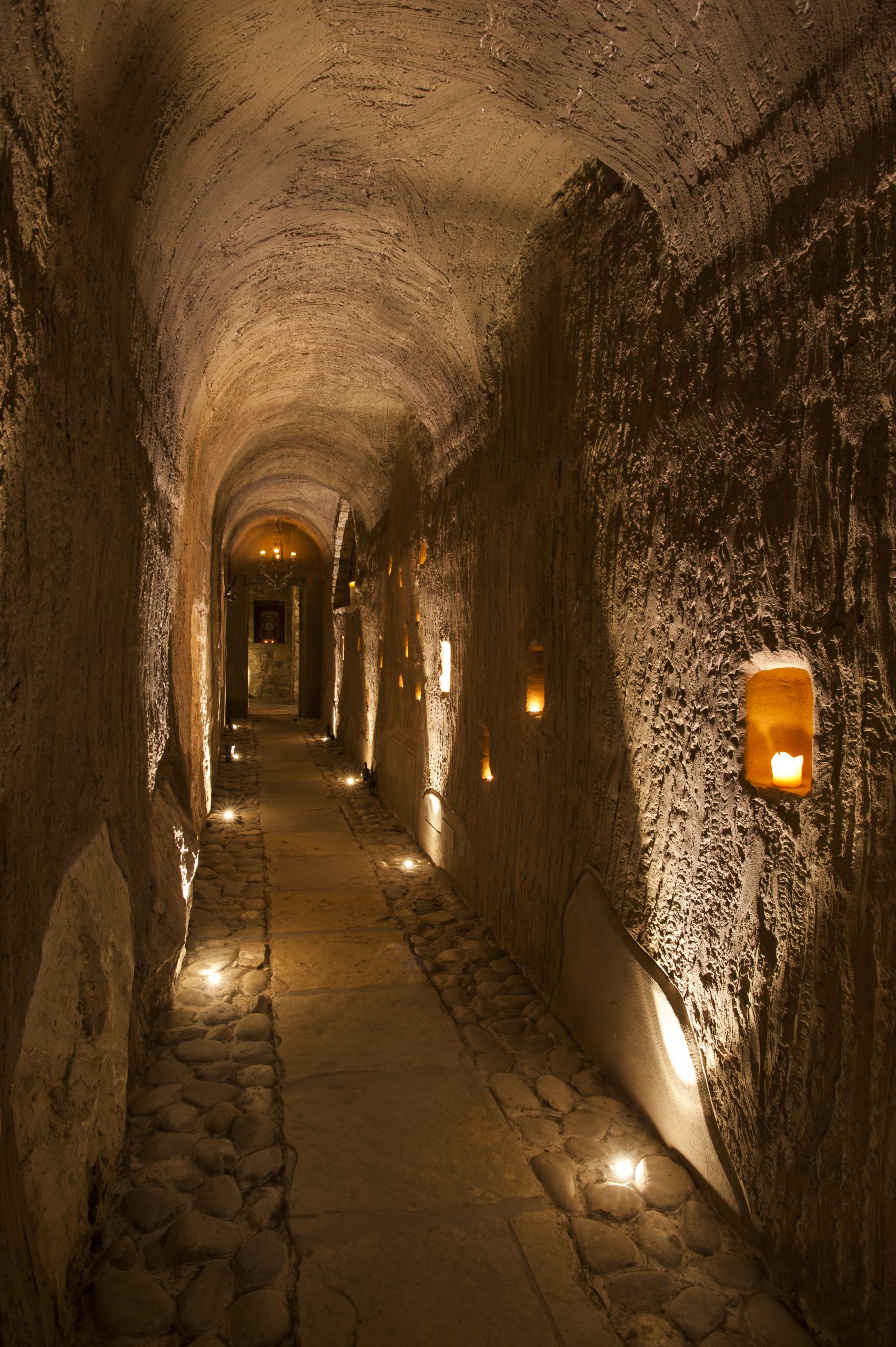 Lungo corridoio illuminato solo da candele e lanterne