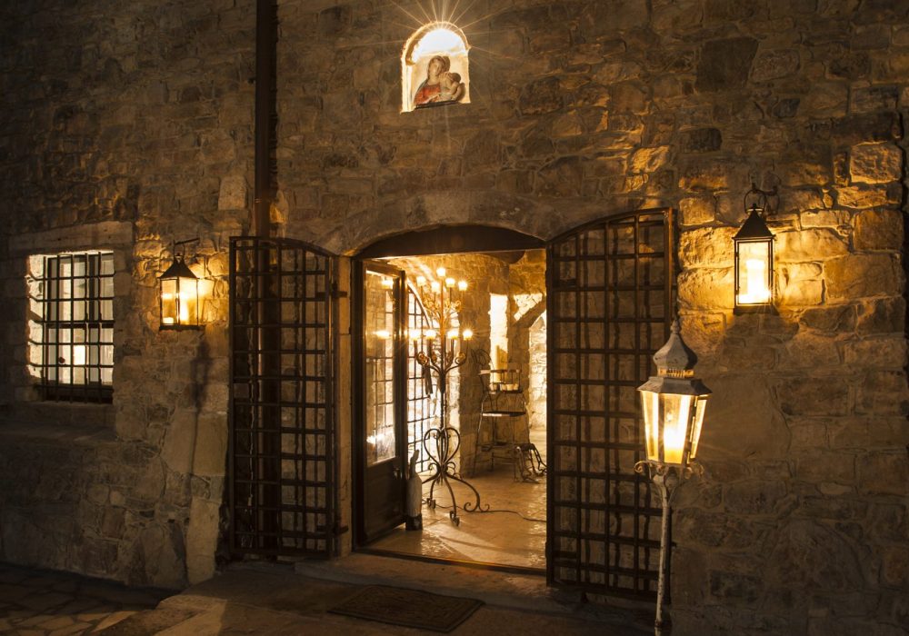 Ingresso notturno di Eremito con cancelli in ferro, lanterne e icona sacra