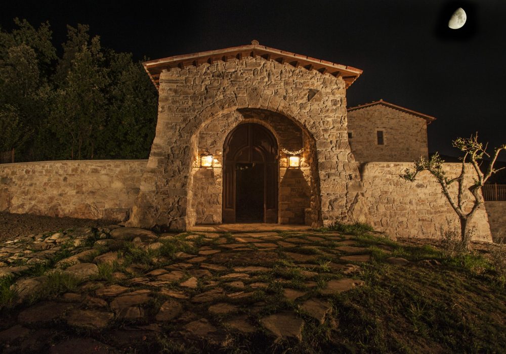 Facciata della cappella di Eremito di notte con vialetto acciottolato