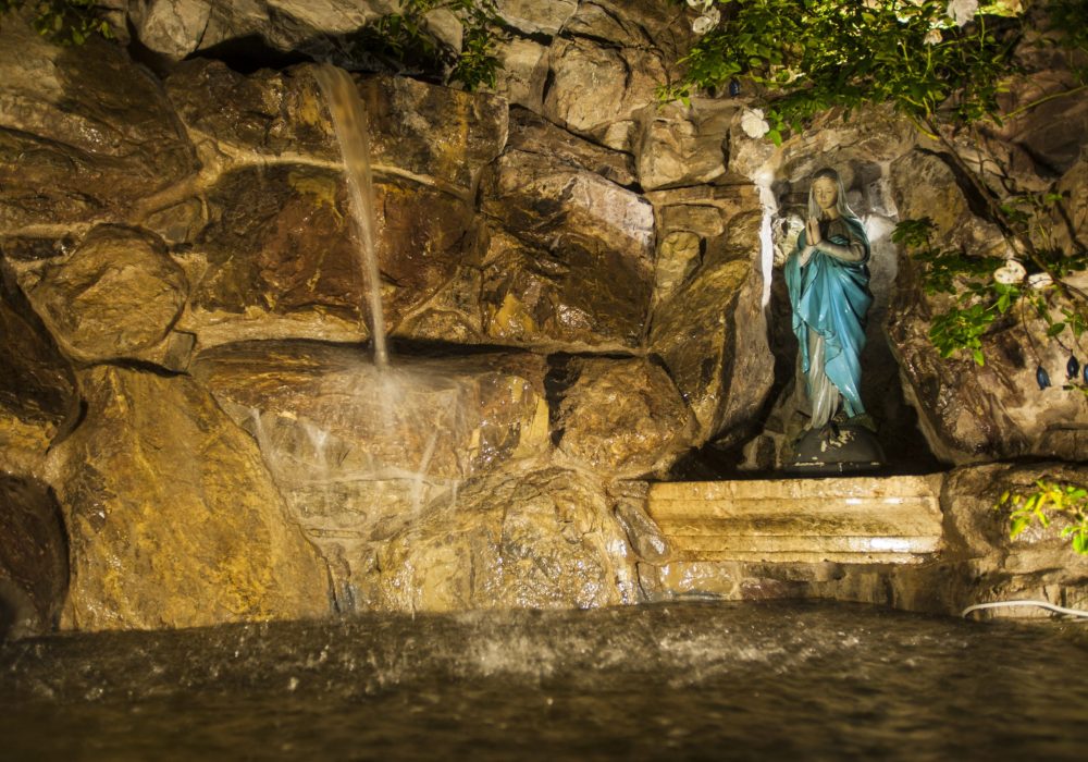 Grotta con cascata e statua della Madonna nel parco di Eremito