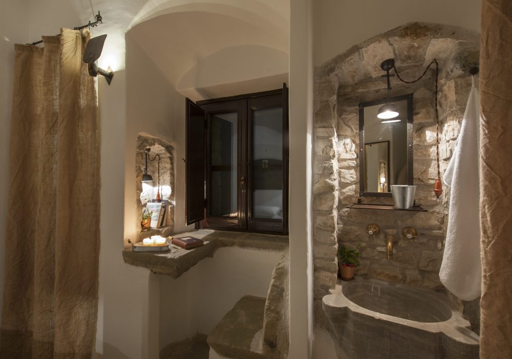 Bagno di una celluzza con lavabo in pietra e finestra sulla valle