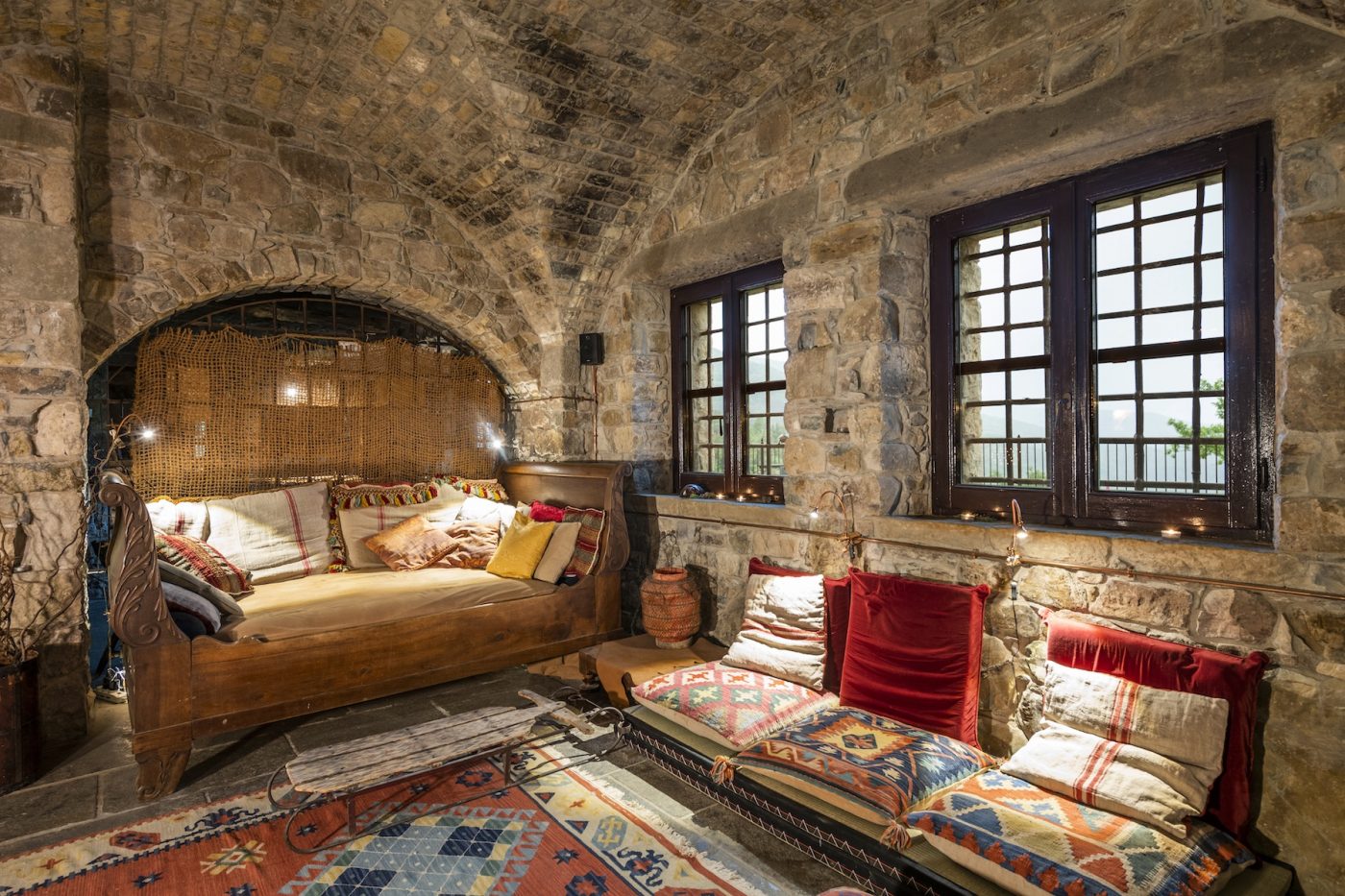 Salone voltato di Eremito con divano letto e finestre ad arco sulla valle