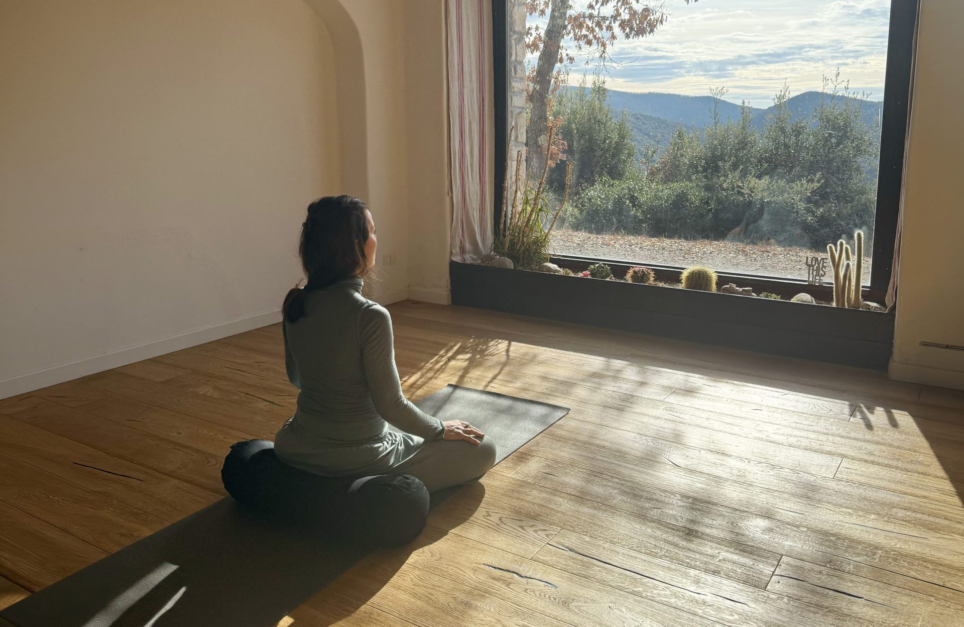 Ospite seduta in meditazione davanti alla finestra affacciata sulle colline umbre