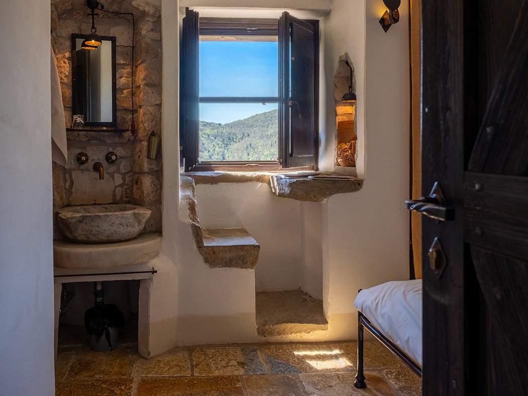 Celluzza Valle, lavabo in pietra e finestra aperta sui boschi della valle umbra
